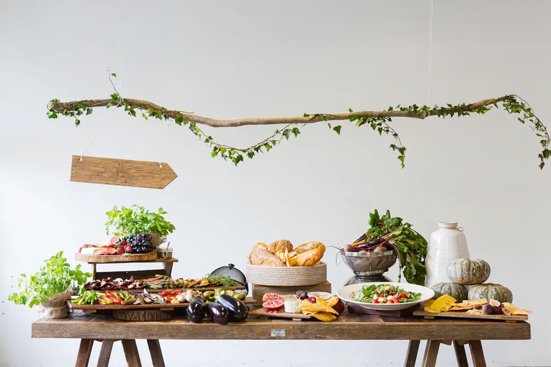 A grazing table of breads, cheeses and salads on a rustic wood console